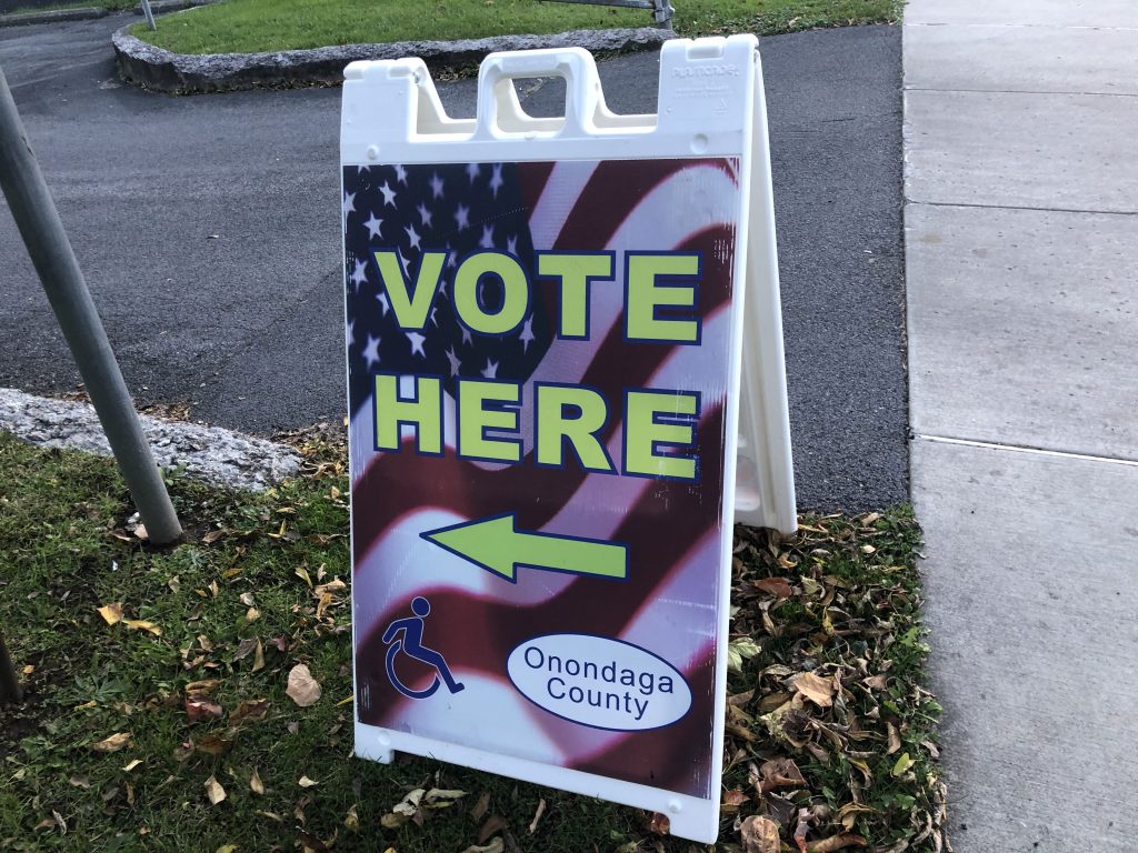 A "vote here" sign in the parking lot at the Reformed Church of Syracuse
