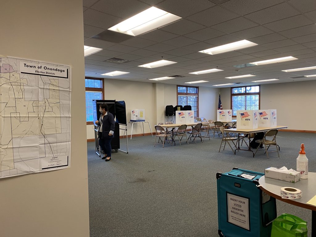Inside of the Onondaga Town Hall polling place. Voting booths in center and map of Onondaga voting districts on wall on the left.