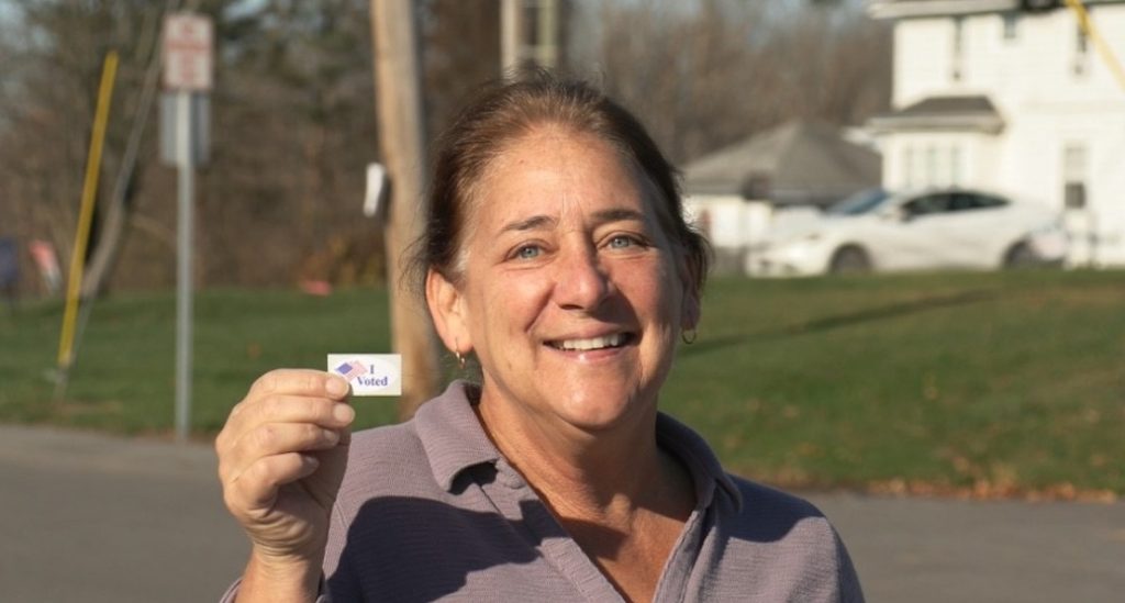 Female voter smiling with sticker
